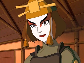 Suki wearing red and gold Fire Nation warrior attire stands confidently with a determined and focused expression against a neutral background that emphasizes her presence.